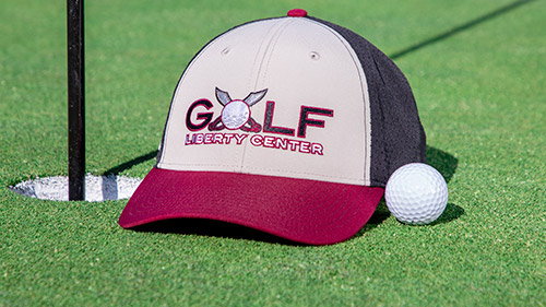 A golf hat resting on the putting green