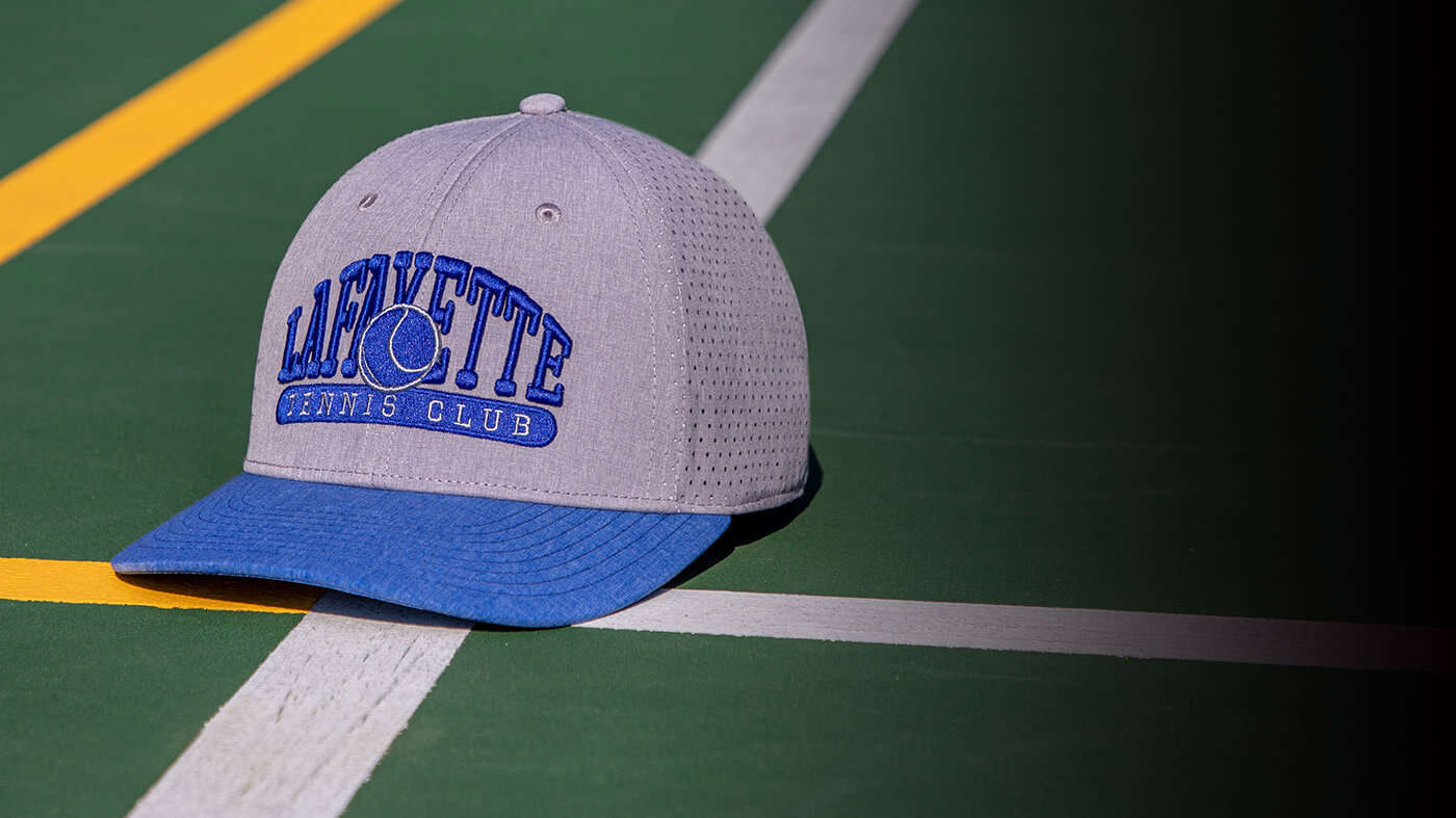 Team Tennis Hats by a tennis net