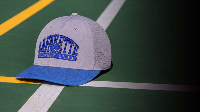 Team Tennis Hats by a tennis net