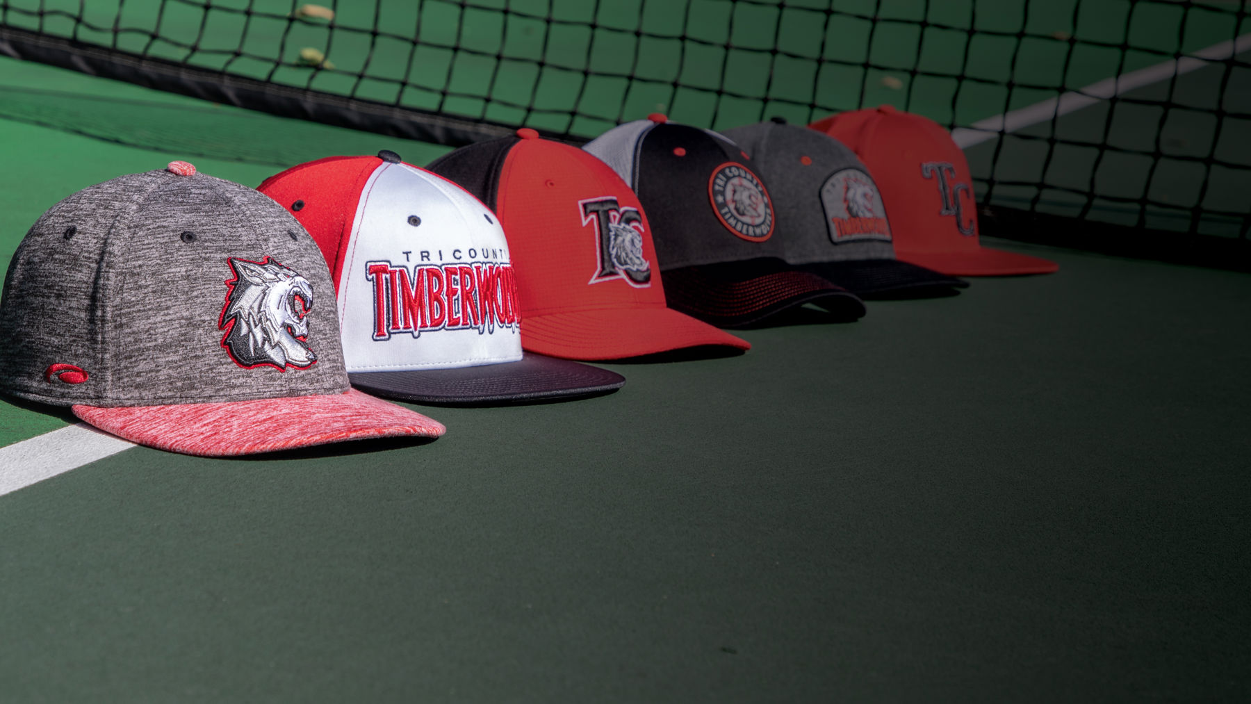 Multi-sport hats sitting on tennis court
